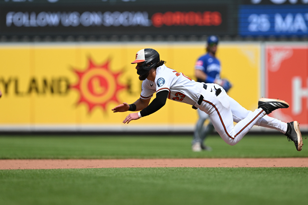 Baltimore Orioles' Blaze Alexander dives safely for second base after getting a late start on a popup lost in the sun to Kansas City Royals right fielder Jac Caglianone in the sixth inning of a baseball game Sunday, July 12, 2026, in Baltimore. (AP Photo/Gail Burton)