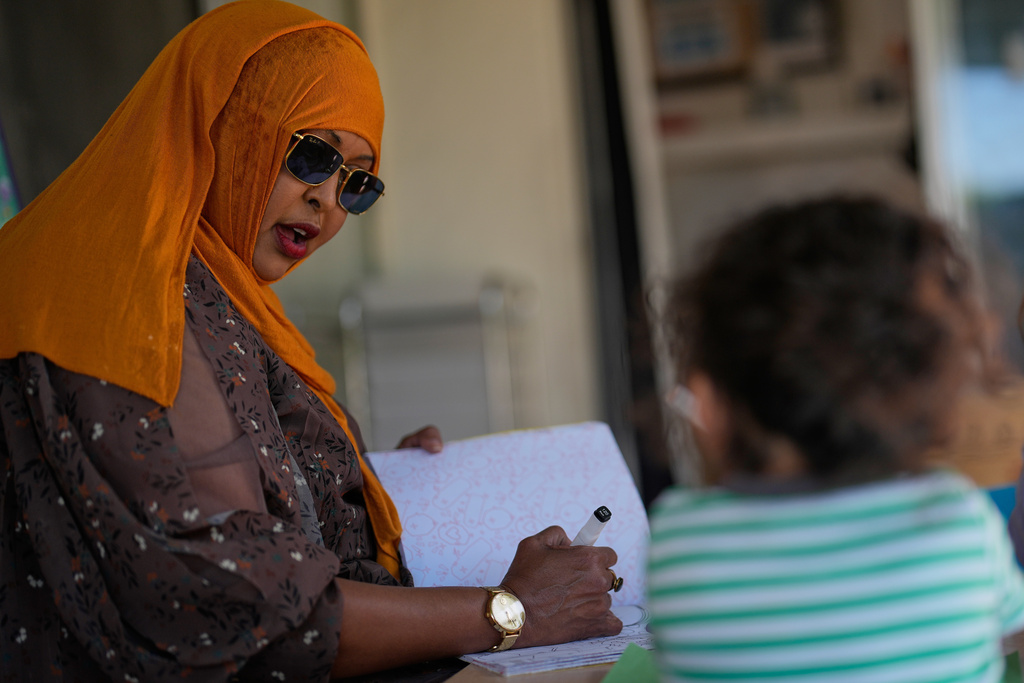 Samsam Khalif works with children at her home-based child care center Friday, Jan. 30, 2026, in San Diego. (AP Photo/Gregory Bull)