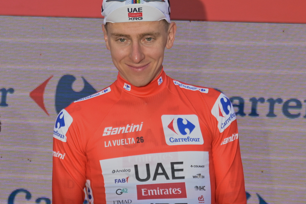 Slovenia's Tadej Pogacar, wearing the overall leader's red jersey celebrates on the podium after the second stage of the La Vuelta cycling race, with start in Monaco and finish in Manosque, France, Sunday, Aug. 23, 2026. (AP Photo/Philippe Magoni)