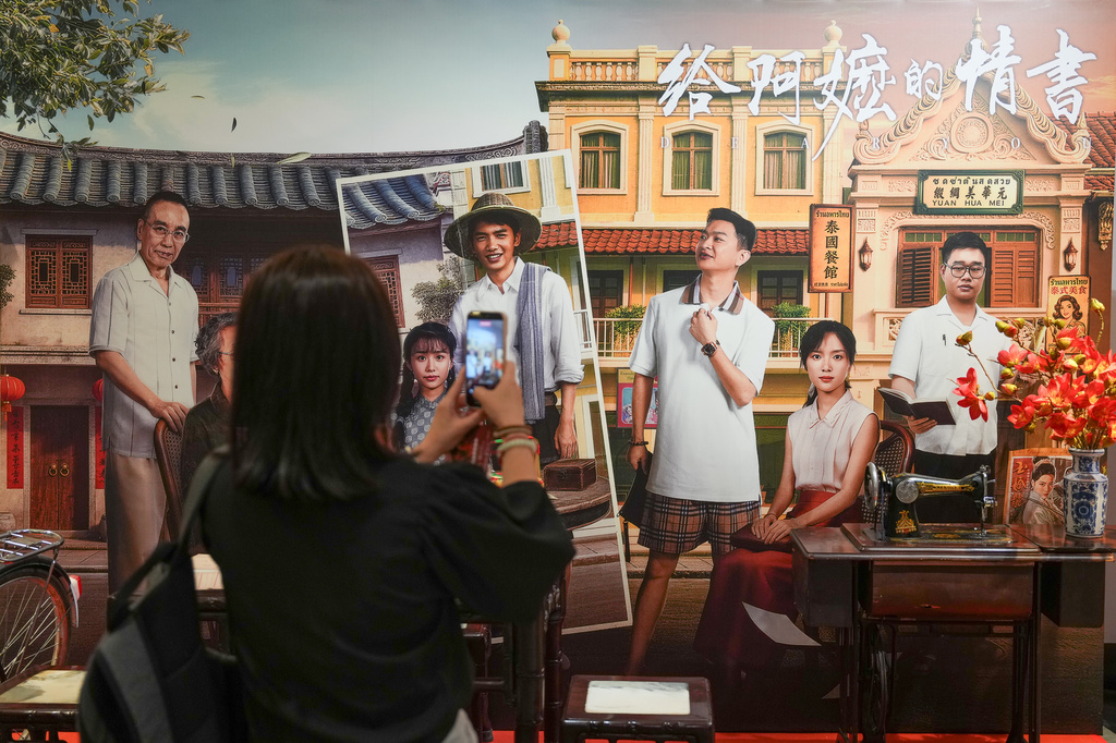 In this photo released by Xinhua News Agency, a woman takes photos during the special screening of Chinese film "Dear You" in Kuala Lumpur, Malaysia, on June 15, 2026. (Chen Zeguo/Xinhua via AP)