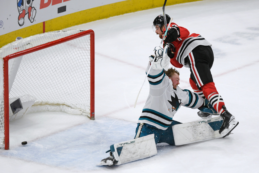 FILE - Chicago Blackhawks' Zachary Sanford (13) collides with San Jose Sharks goalie Mackenzie Blackwood (29) during the shootout in an NHL hockey game Jan 16, 2024, in Chicago. (AP Photo/Paul Beaty, File)