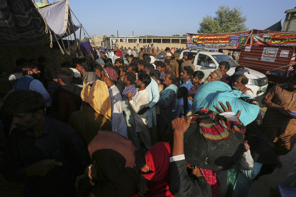 Villagers jostle to get aid from a relief camp set up by local administration for the victims of flood hit area in Jalalpur Pirwala, in Multan district, Pakistan, Wednesday, Sept. 10, 2025. (AP Photo/Asim Tanveer)