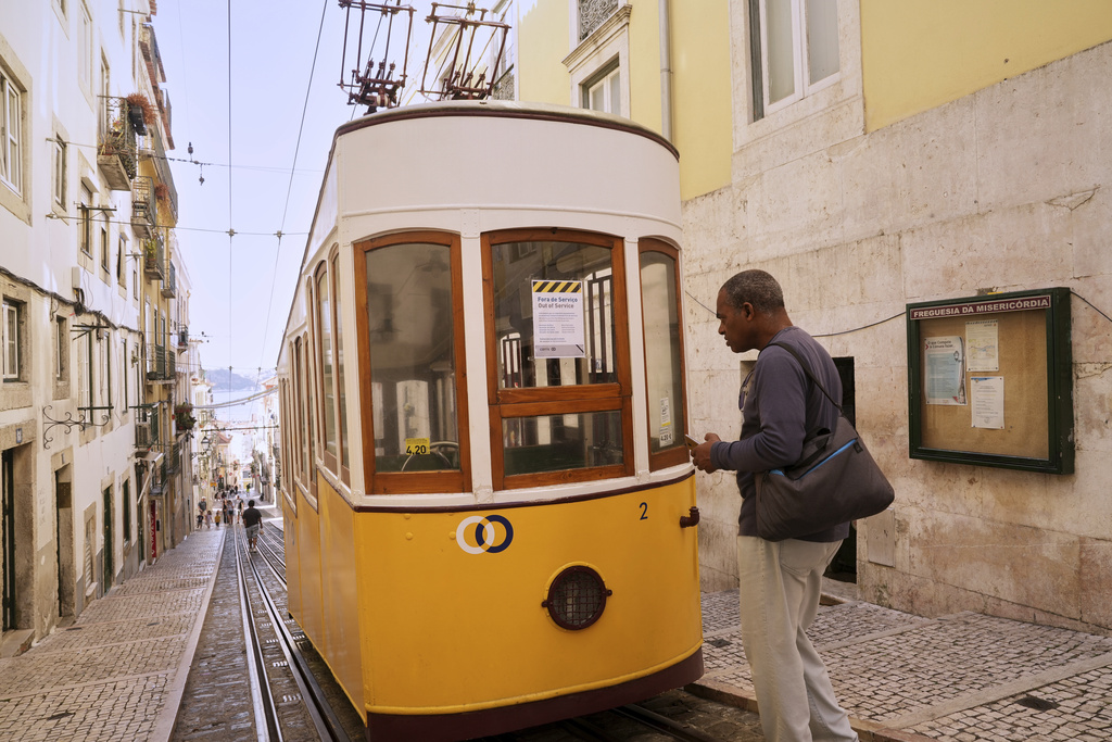 A man reads a sign announcing that the streetcar is out of service in Lisbon, Portugal, Thursday, Sept. 4, 2025. (AP Photo/Ana Brigida)