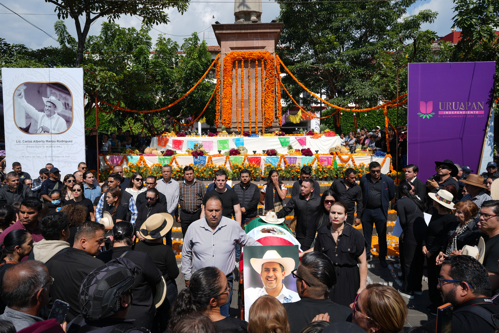 People gather to honor late Mayor Carlos Alberto Manzo Rodríguez, who was shot during Day of the Dead celebrations, in Uruapan, Michoacan state, Mexico, Sunday, Nov. 2, 2025. (AP Photo/Eduardo Verdugo)