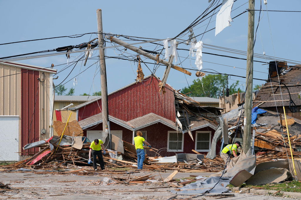 Volunteers clean up debris in front of damaged businesses after a tornado hit the day before, Tuesday, July 28, 2026, in Menasha, Wis. (AP Photo/Kayla Wolf)