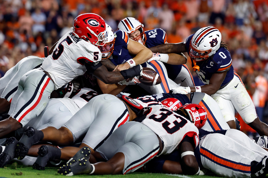 Georgia linebacker Raylen Wilson (5) knocks the ball out of the hands of Auburn quarterback Jackson Arnold (11) as he dives for the end zone during the first half of an NCAA college football game, Saturday, Oct. 11, 2025, in Auburn, Ala. (AP Photo/Butch Dill)