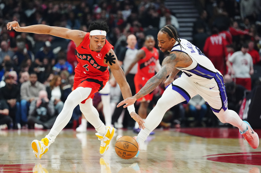 Toronto Raptors' Scottie Barnes (4) and Sacramento Kings' DeMar DeRozan (10) battle for the ball during the first half of an NBA basketball game in Toronto, Wednesday, April 1, 2026. (Frank Gunn/The Canadian Press via AP)