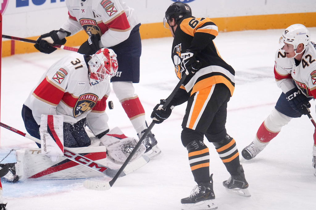 Pittsburgh Penguins' Rickard Rakell, center, has his shot blocked by Florida Panthers goalie Cooper Black (31) during the first period of an NHL hockey game in Pittsburgh, Thursday, Oct. 22, 2026. (AP Photo/Gene J. Puskar)