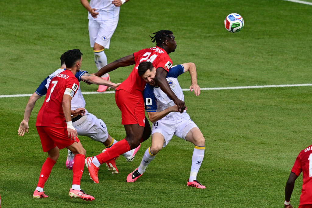 Canada's Promise David (24) grapples with Bosnia Armin Gigovic (8) during the second half of the World Cup Group B soccer match between Canada and Bosnia, Friday, June 12, 2026, in Toronto. (Sammy Kogan/The Canadian Press via AP)