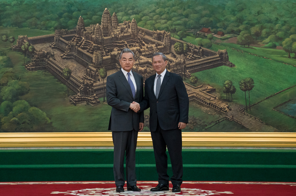 In this photo released by Agence Kampuchea Press (AKP), Chinese Foreign Minister Wang Yi, left, shakes hands with Cambodian Prime Minister Hun Manet prior to a meeting at Peace Palace in Phnom Penh, Cambodia, Wednesday, April 22, 2026. (Agence Kampuchea Press via AP)
