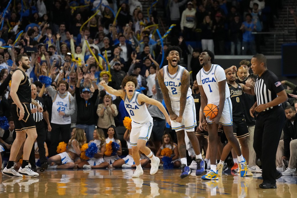 UCLA's Trent Perry (0), Donovan Dent (2) and Xavier Booker (1) celebrate after defeating Purdue in an NCAA college basketball game in Los Angeles, Tuesday, Jan. 20, 2026. (AP Photo/Jae C. Hong)