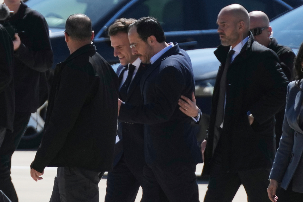 French President Emmanuel Macron, background, is welcomed by Cyprus President Nikos Christodoulides, foreground, at Andreas Papandreou Air Base in Paphos, Cyprus, on Monday, March 9, 2026. (AP Photo/Petros Karadjias)