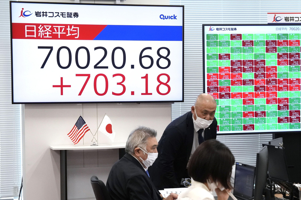 An electronic board, left, shows Nikkei index at a securities company in Tokyo Tuesday, June 16, 2026. (Shinji Kouchi/Kyodo News via AP)