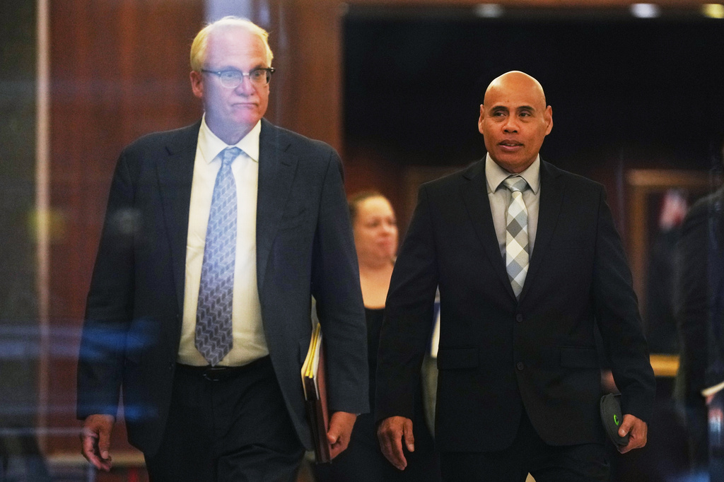 Christian Castro, right, an immigration officer who is accused of shooting a Venezuelan man during the immigration crackdown in Minneapolis early this year and lying to investigators about what happened, leaves with his attorney Daniel Gerdts, left, after a hearing at the Warren E. Burger Federal Building, Friday, Sept. 18, 2026, in St. Paul, Minn. (AP Photo/Ellen Schmidt)
