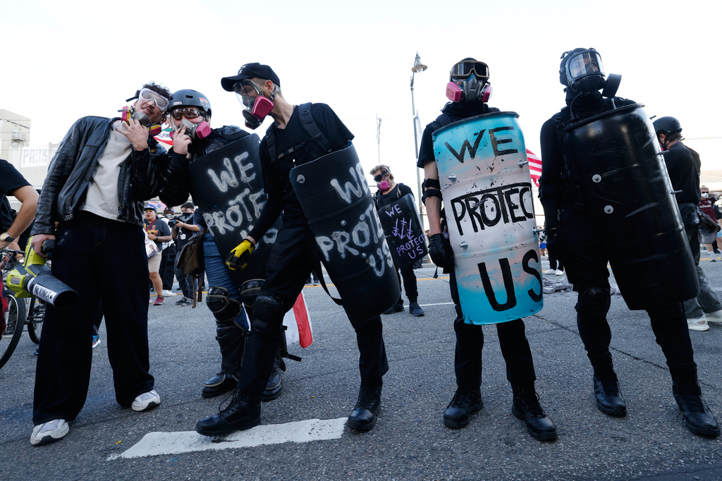 Protesters stand off against police outside the Metropolitan Detention Center in downtown Los Angeles during a "No Kings" rally Saturday, March 28, 2026. (AP Photo/Jill Connelly)