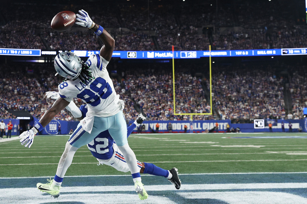 Dallas Cowboys wide receiver Ceedee Lamb (88) tries to pull a catch against New York Giants defensive back Andru Phillips during the second half of an NFL football game Sunday, Sept. 13, 2026, in East Rutherford, N.J. (AP Photo/Pamela Smith)