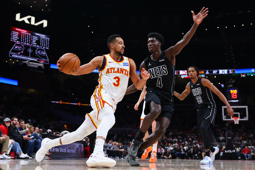 Atlanta Hawks guard CJ McCollum (3) dribbles against Brooklyn Nets guard Drake Powell (4) during the first half of an NBA basketball game, Thursday, March 12, 2026, in Atlanta. (AP Photo/Colin Hubbard)