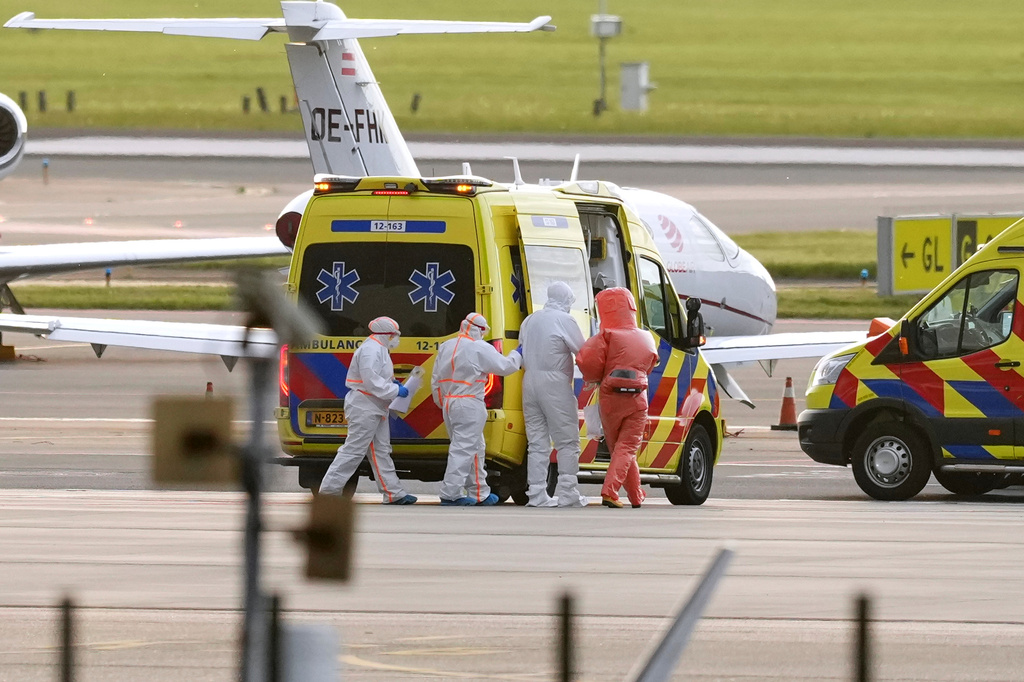 Medics escort a patients, evacuated from the MV Hondius cruise ship with suspected hantavirus infection, to an ambulance after being flown to Schiphol airport, Amsterdam, Netherlands, Wednesday, May 6, 2026. (AP Photo/Peter Dejong)
