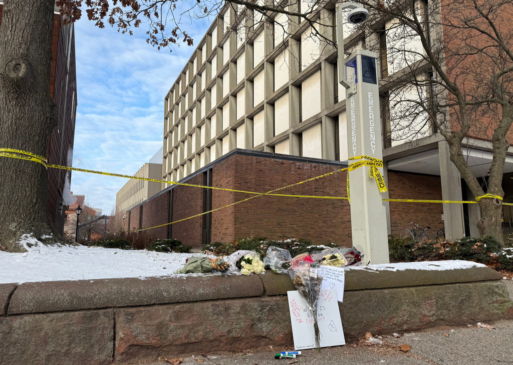 A memorial of flowers and signs lay outside the Barus and Holley engineering building at Brown University, on Hope Street in Providence, R.I., on Tuesday, Dec 16, 2025. (AP Photo/Matt OBrien)