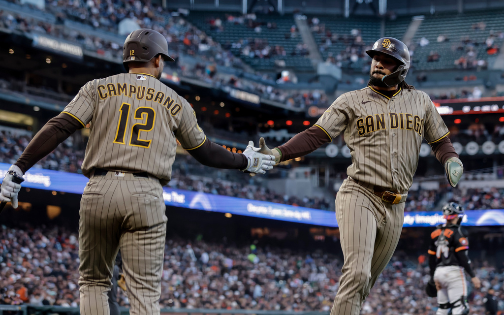 San Diego Padres' Luis Campusano (12) high-fives Fernando Tatis Jr. (23) after he scored on a hit by Nick Castellanos in the fourth inning of a baseball game against the San Francisco Giants in San Francisco on Tuesday, May 5, 2026. (Carlos Avila Gonzalez/San Francisco Chronicle via AP)