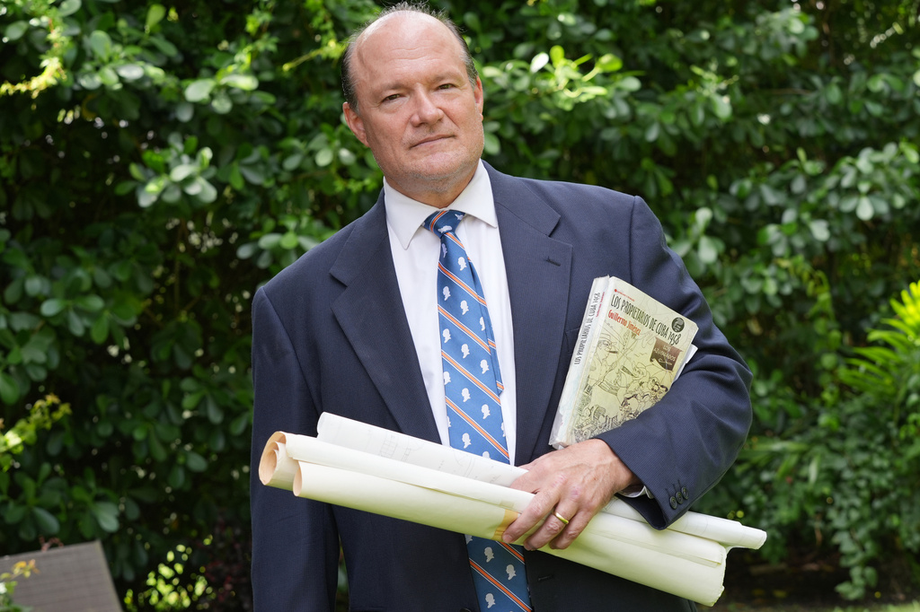 Nick Gutiérrez, President of the National Association of Cuban Landowners in Exile, holds architecture renderings of stolen properties by the Cuban government, Tuesday, April 21, 2026, in Coral Gables, Fla. (AP Photo/Marta Lavandier)