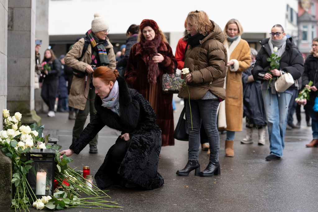 People lay down flowers in tribute to the victims after the official commemorative ceremony for the victims of the deadly fire at the "Le Constellation" bar in Crans-Montana, in Zurich, Switzerland, Friday, Jan. 9, 2026. (Claudio Thoma/Keystone/Pool via AP)