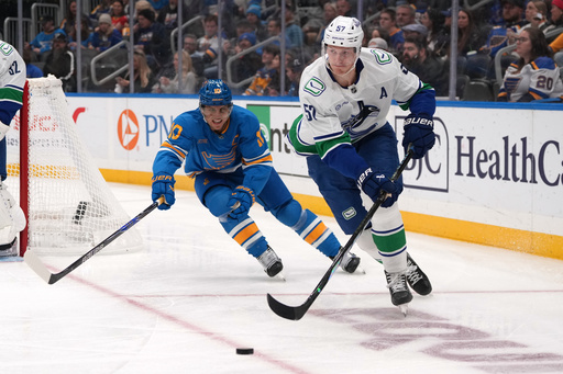 Vancouver Canucks' Tyler Myers (57) passes as St. Louis Blues center Brayden Schenn (10) defends during the second period of an NHL hockey game Thursday, Oct. 30, 2025, in St. Louis. (AP Photo/Jeff Roberson) Vancouver Canucks' Tyler Myers (57) passes as St. Louis Blues center Brayden Schenn (10) defends during the second period of an NHL hockey game Thursday, Oct. 30, 2025, in St. Louis. (AP Photo/Jeff Roberson)