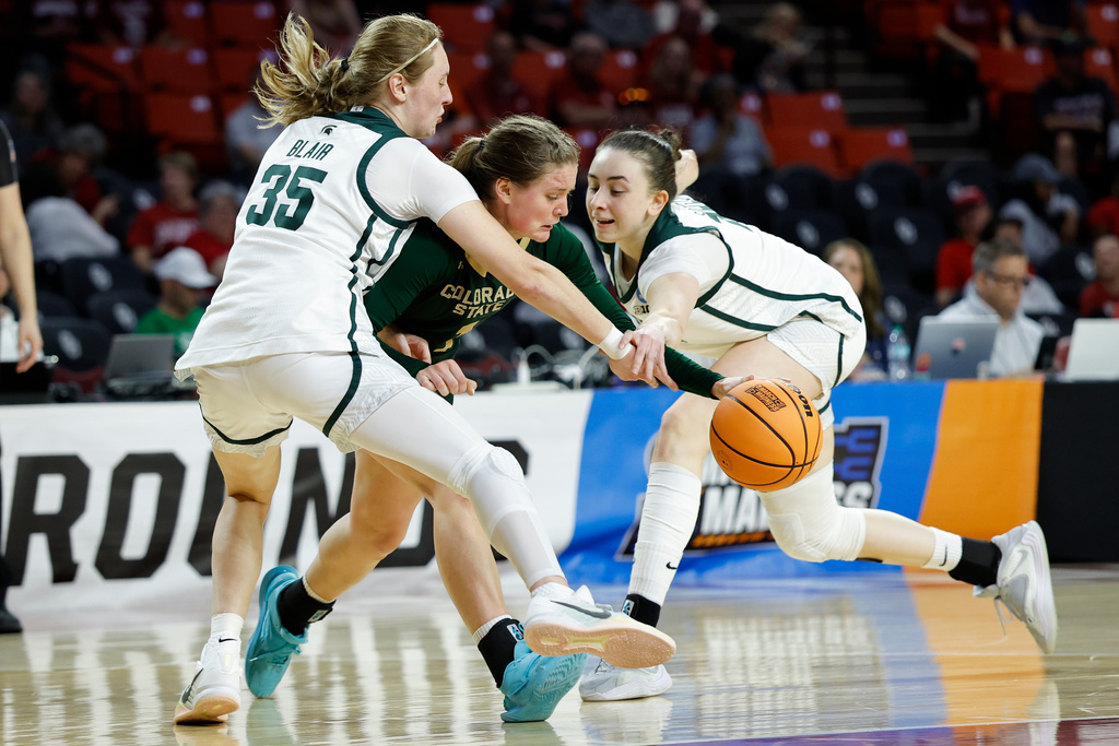 Colorado State guard Kloe Froebe (1) drives between Michigan State guard Kennedy Blair (35) and forward Grace Vanslooten (14) during the second half in the first round of the NCAA college basketball tournament Friday, March 20, 2026, Norman, Okla. (AP Photo/Alonzo Adams)