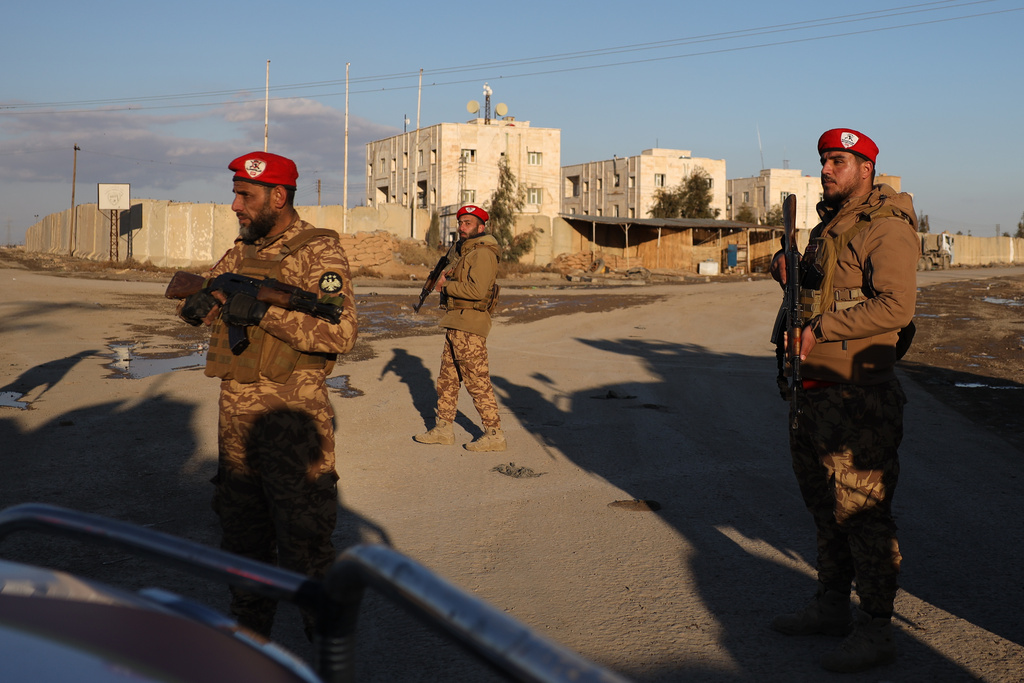 Syrian government forces stand guard outside Al-Aqtan prison on the outskirts of Raqqa, northeastern Syria, Monday, Jan. 19, 2026, as negotiations are underway between the Syrian government and the Kurdish-led Syrian Democratic Forces over a withdrawal from the prison. (AP Photo/Omar Albam)