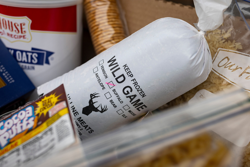 A box of food includes buffalo meat, harvested from the Fort Peck Assiniboine & Sioux Tribes Buffalo Ranch, at a food distribution site in Frazer, Mont., on Monday, Nov. 10, 2025. (AP Photo/Mike Clark)