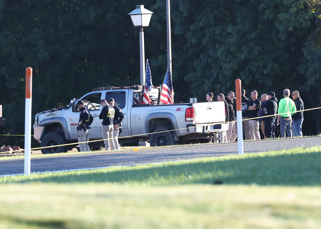 ATF police stand outside the vehicle used to ram the exterior of the Church of Jesus Christ of Latter-day Saints, Monday, Sept. 29, 2025 in Grand Blanc Township, Mich. (AP Photo/Carlos Osorio)