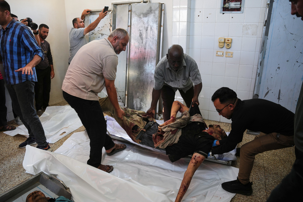 EDS NOTE: GRAPHIC CONTENT - Palestinians carry the body of Ali Asbitan, 28, who was killed in an Israeli airstrike, at Al-Aqsa Hospital in Deir al-Balah, Gaza Strip, Monday, June 29, 2026. (AP Photo/Abdel Kareem Hana)
