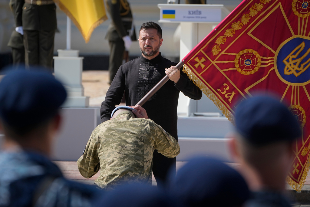 Ukraine's President Volodymyr Zelenskyy hands over the flag of a military unit during the ceremony to mark Ukraine Independence Day in Kyiv, Ukraine, Monday, Aug. 24, 2026. (AP Photo/Efrem Lukatsky)