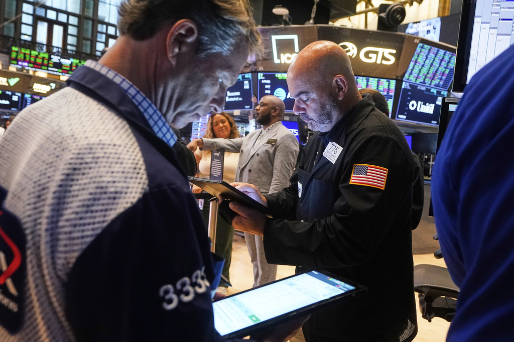 Traders Robert Charmak, left, and Fred Demarco work on the floor of the New York Stock Exchange, Friday, Aug. 15, 2025. (AP Photo/Richard Drew)