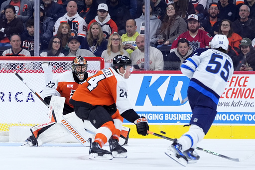 Winnipeg Jets' Mark Scheifele (55) scores a goal against Philadelphia Flyers' Nick Seeler (24) and Samuel Ersson (33) during the second period of an NHL hockey game, Thursday, Oct. 16, 2025, in Philadelphia. (AP Photo/Matt Slocum) Winnipeg Jets' Mark Scheifele (55) scores a goal against Philadelphia Flyers' Nick Seeler (24) and Samuel Ersson (33) during the second period of an NHL hockey game, Thursday, Oct. 16, 2025, in Philadelphia. (AP Photo/Matt Slocum)