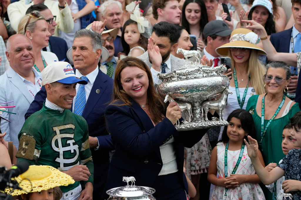 Trainer Cherie DeVaux, center, with Jockey Jose Ortiz, left, holds the trophy after Golden Tempo won the 158th running of the Belmont Stakes horse race, Saturday, June 6, 2026, in Saratoga Springs, N.Y. (AP Photo/Yuki Iwamura)