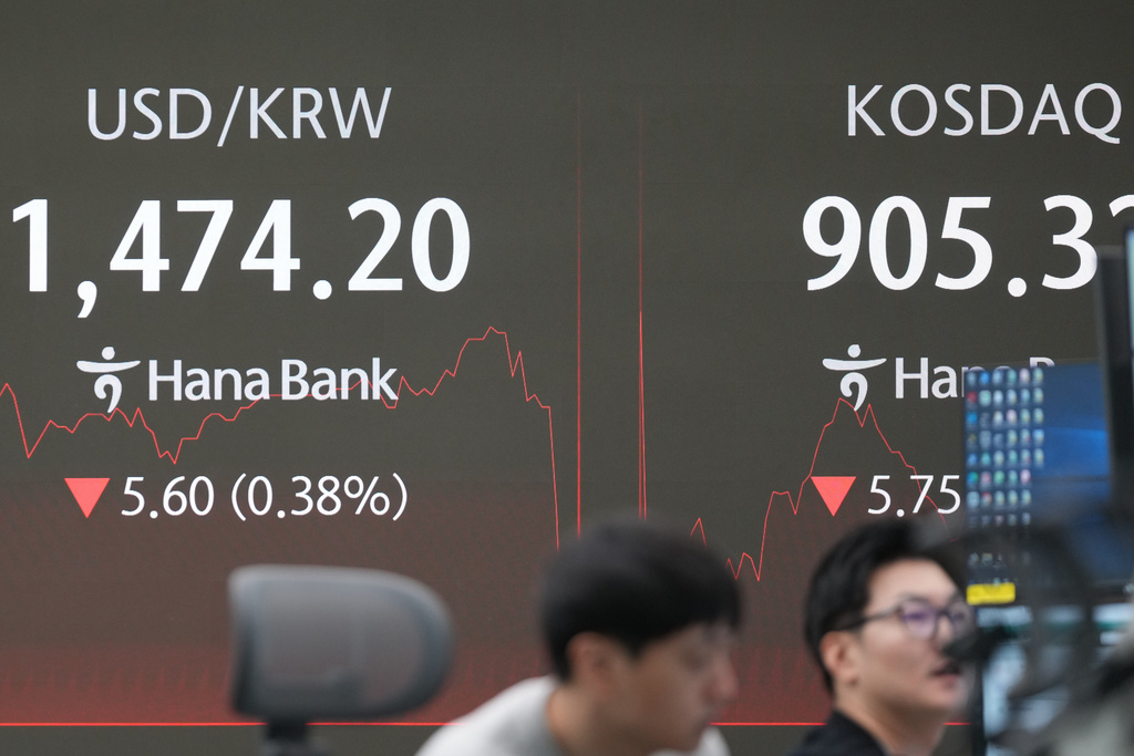 Dealers work near the screens showing the foreign exchange rate between U.S. dollar and South Korean won, left, and the Korean Securities Dealers Automated Quotations (KOSDAQ) at a dealing room of Hana Bank in Seoul, South Korea, Thursday, Dec. 18, 2025. (AP Photo/Lee Jin-man)