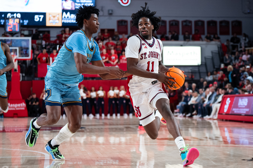 St. John's guard Ian Jackson (11), defended by Quinnipiac forward Keith McKnight (21), heads toward the basket during the second half of an NCAA college basketball game, Monday, Nov. 3, 2025, in New York. (AP Photo/Angelina Katsanis)