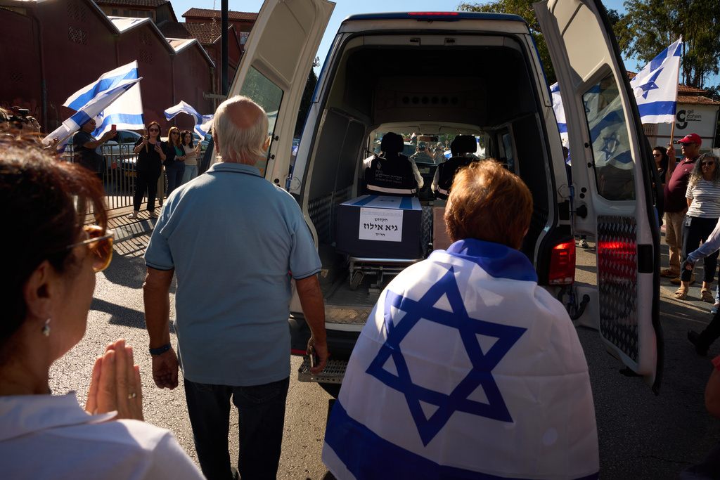 Mourners walk near the car carrying the coffin of slain hostage Guy Illouz during his funeral procession in Rishon Lezion, Israel, Wednesday, Oct. 15, 2025. Illouz remains were returned from Gaza to Israel as part of a ceasefire agreement between Israel and Hamas. (AP Photo/Emilio Morenatti)