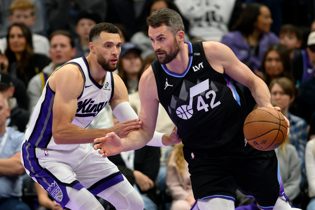 Utah Jazz forward Kevin Love, right, drives to the basket while guarded by Sacramento Kings guard Zach LaVine, left, during the first half of an NBA Cup basketball game Friday, Nov. 28, 2025, in Salt Lake City. (AP Photo/Tyler Tate)