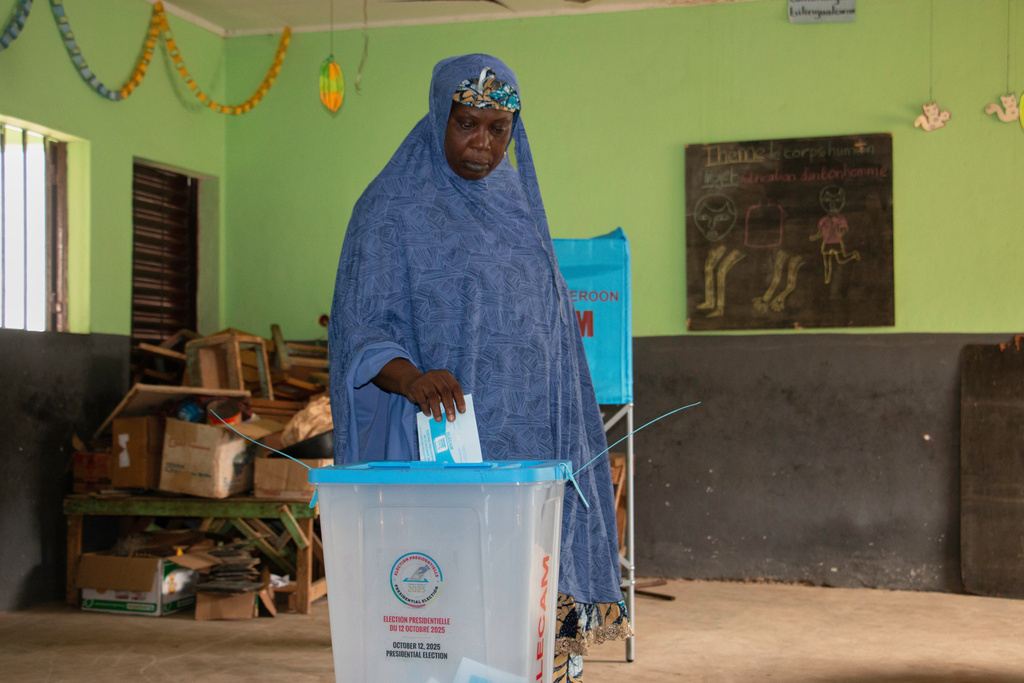 A woman casts her ballot at a polling station during the presidential election in Garoua, Cameroon, Sunday, Oct. 12, 2025. (AP Photo/Welba Yamo Pascal)