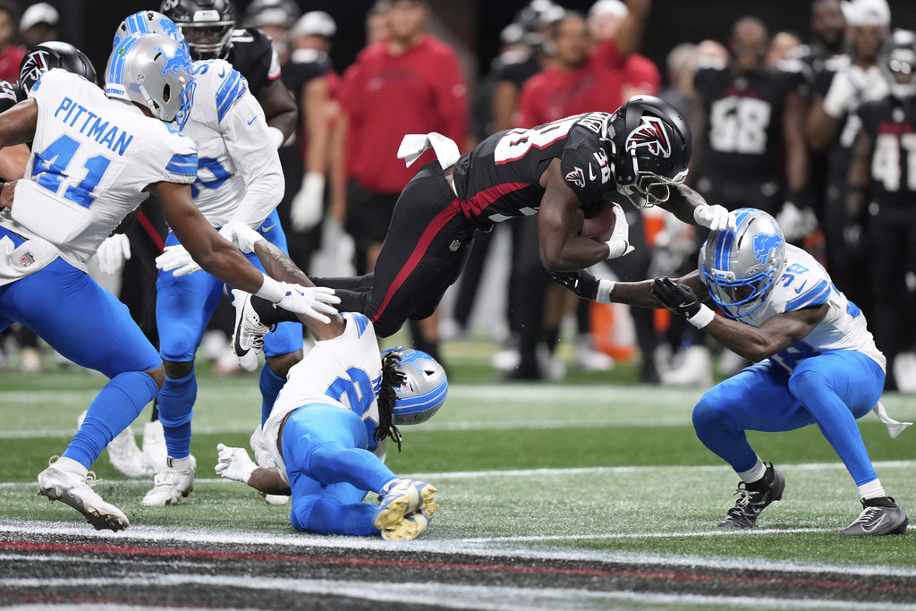 Detroit Lions safety Morice Norris (26) is hit in the helmet by Atlanta Falcons running back Nathan Carter (38) during the second half of an NFL preseason football game Friday, Aug. 8, 2025, in Atlanta. (AP Photo/Brynn Anderson)