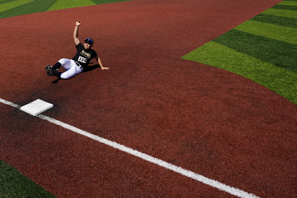 Rakyung Kim slides to third base during the first day of tryouts for the Women's Professional Baseball League, Friday, Aug 22, 2025, at the Washington Nationals Youth Baseball Academy in Washington. (AP Photo/Julia Demaree Nikhinson)