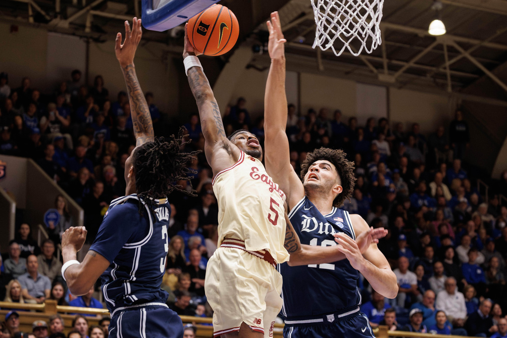 Boston College's Fred Payne (5) jumps to dunk between Duke's Isaiah Evans, left, and Cameron Boozer during the first half of an NCAA college basketball game in Durham, N.C., Tuesday, Feb. 3, 2026. (AP Photo/Ben McKeown)