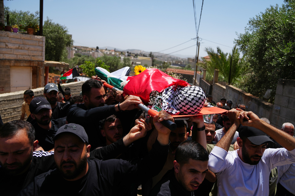 Mourners carry the body of Palestinian Zakaria Qatousa, during his funeral in the West Bank town of Deir Qaddis Wednesday, May 13, 2026. (AP Photo/Mahmoud Illean)