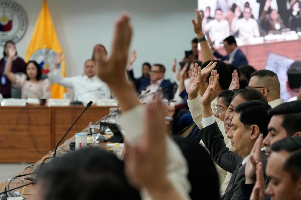 Members of Congress justice committee raise their hands as they vote during a congressional hearing on an impeachment bid against Vice President Sara Duterte at the House of Representatives in Quezon, Philippines Wednesday, April 29, 2026. (AP Photo/Aaron Favila)