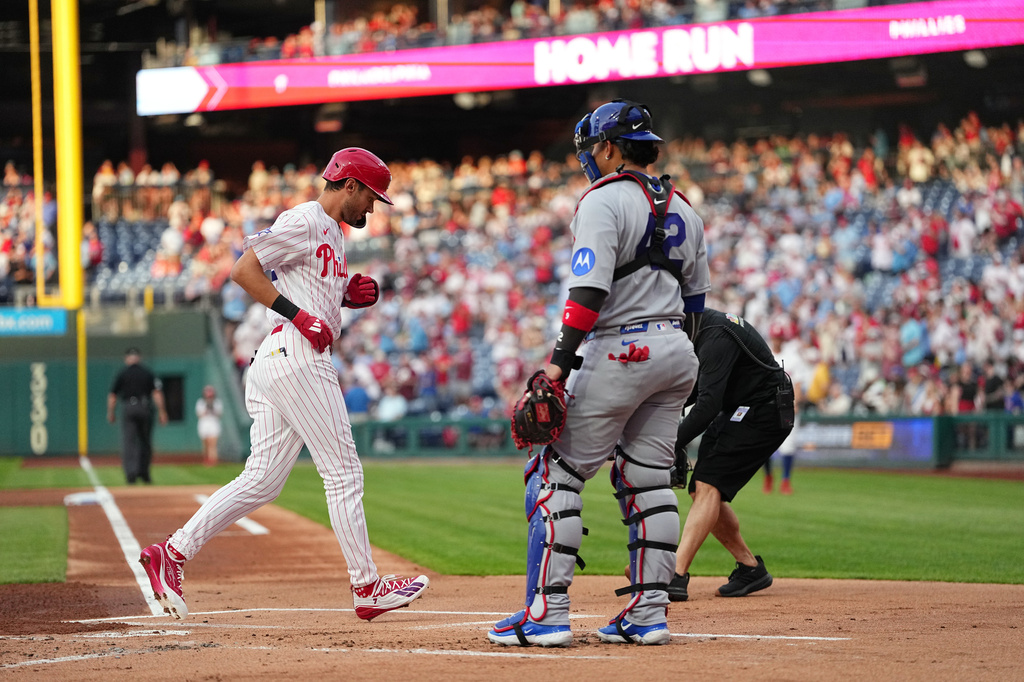 Philadelphia Phillies' Trea Turner scores past catcher Miguel Amaya after hitting a home run off of pitcher Shota Imanaga during the first inning of a baseball game, Wednesday, April 15, 2026, in Philadelphia. (AP Photo/Matt Rourke)