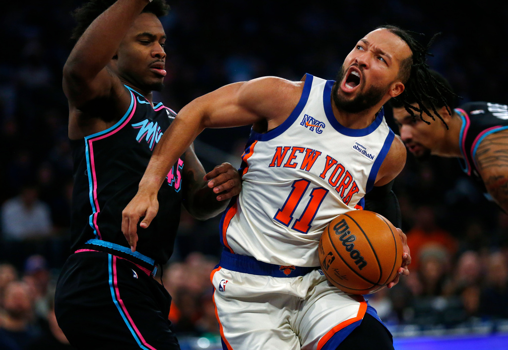 Miami Heat guard Davion Mitchell, left, defends against New York Knicks guard Jalen Brunson (11) during the first half of an NBA basketball game Sunday, Dec. 21, 2025, in New York. (AP Photo/John Munson)