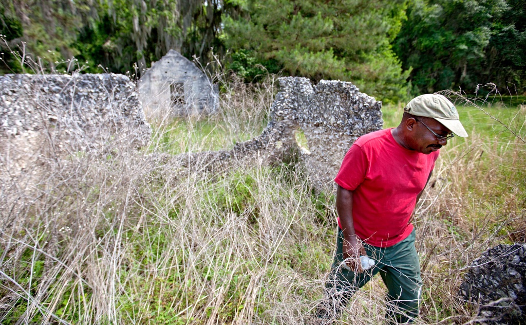 FILE - Ire Gene Grovner walks through remnants of the old slave's quarters at the Chocolate Plantation where his ancestors lived some eight generations ago on Sapelo Island, Ga., on May 16, 2013. (AP Photo/David Goldman, File)