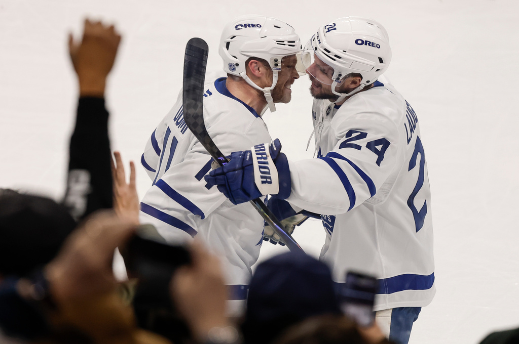Toronto Maple Leafs' Max Domi (11) and Scott Laughton (24) celebrate Domi's overtime game-winning goal against the Winnipeg Jets during NHL action in Winnipeg, Saturday, January 17, 2026. (John Woods/The Canadian Press via AP)